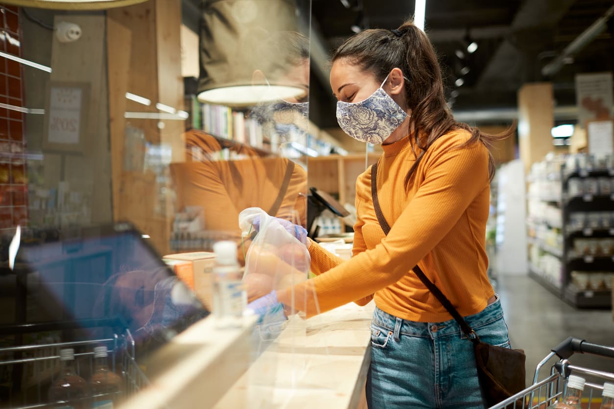 Comprar durante la pandemia Chica en una tienda con mampara | Cofidis Retail